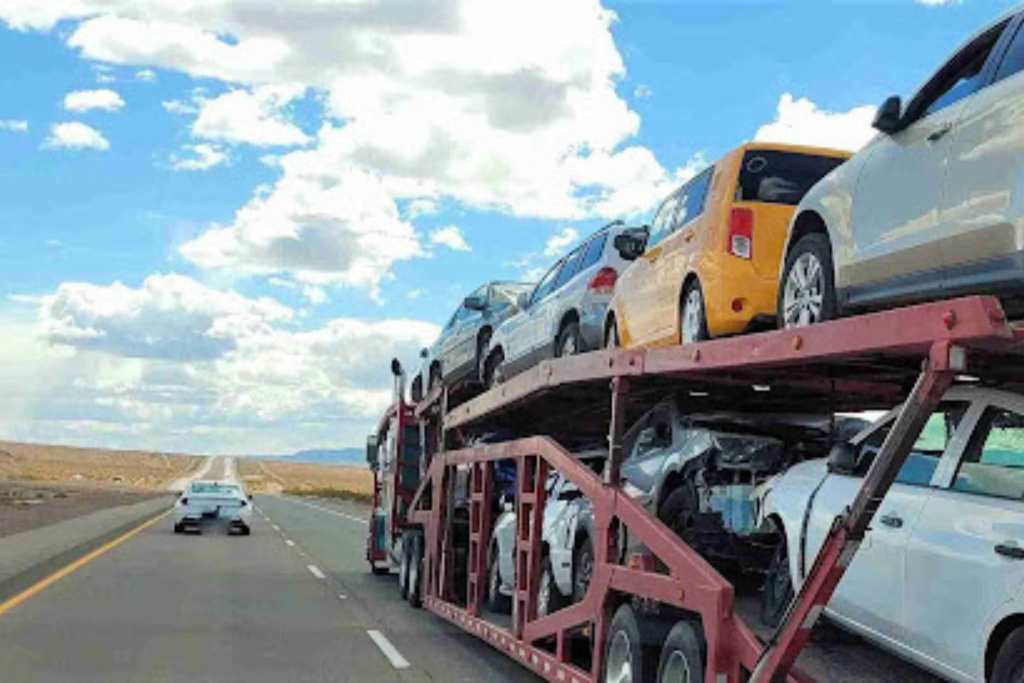 What a Dispatch Fee Is and Why It Exists in Auto Transport Car carrier transporting vehicles on highway, explaining where a dispatch fee in auto transport fits in pricing.