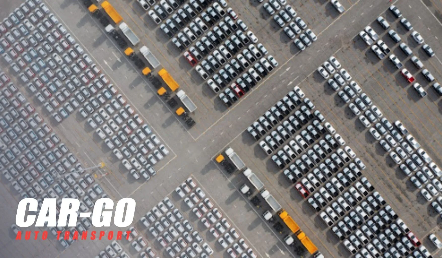 Aerial view of large vehicle storage lot used in hybrid auto transport combining centralized staging with outbound shipping routes.