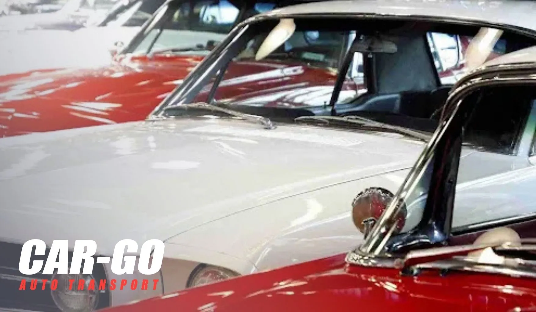 Classic cars parked indoors awaiting transport, illustrating how to ship a non-running car with specialized handling.