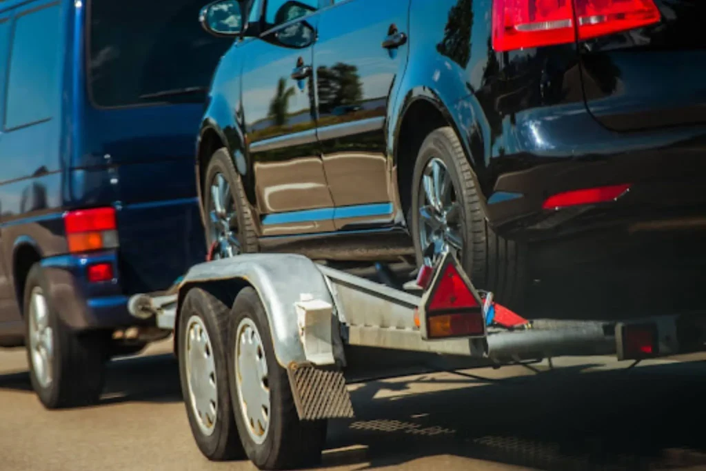 How Long Does It Take to Ship a Car? Average Timelines for Every Route Car trailer transporting vehicle on highway explaining transit factors in How Long Does Car Shipping Take.