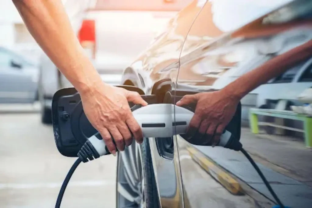 How Auto Transport Is Adapting to Electric Vehicles Electric SUV at a charging station related to auto transport electric vehicles and EV shipping logistics.